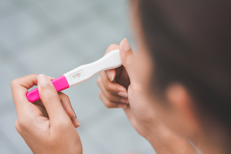 woman looking at pregnancy test